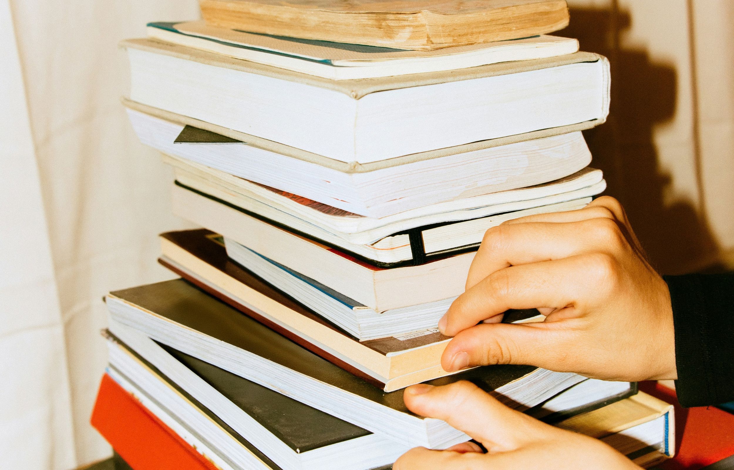 Pila di libri e mano, per articolo su gategate.it