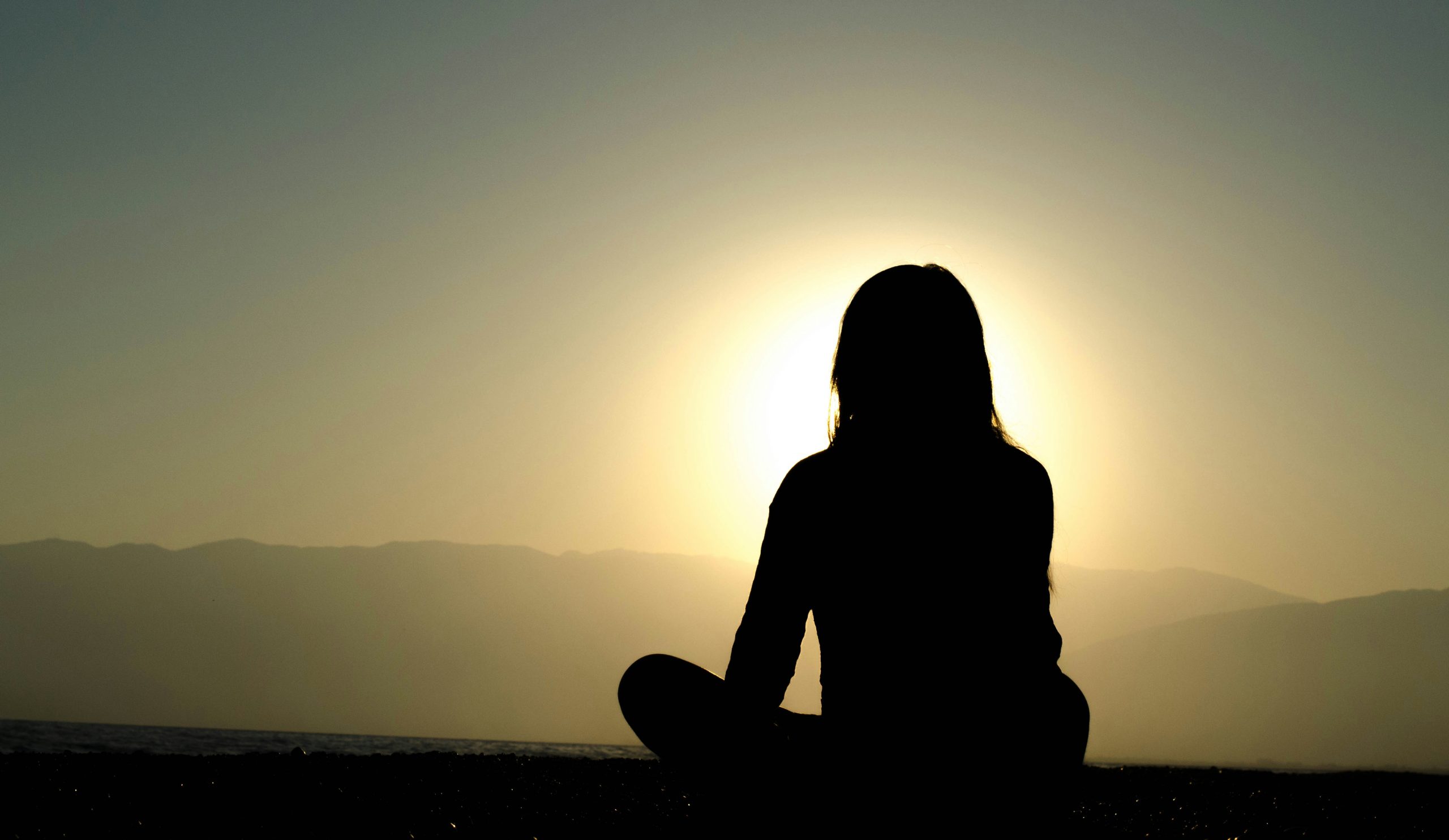 Silhouette in meditazione all'alba